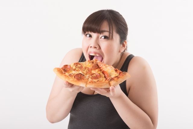 カロリーの高い食べ物を食べる女性